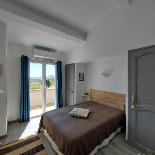 une chambre avec un lit et une grande fenêtre dans l'établissement La Tabarine, à La Croix-Valmer