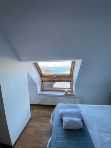 a bedroom with a bed and a large window at EL TRASTERO DE PALMERO in A Coruña