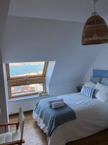 a bedroom with a large bed with a large window at EL TRASTERO DE PALMERO in A Coruña