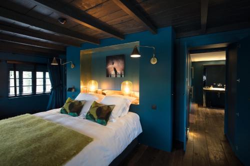 a bedroom with blue walls and a large bed at Domaine du Kaegy - Hébergements 5 étoiles in Steinbrunn-le-Bas