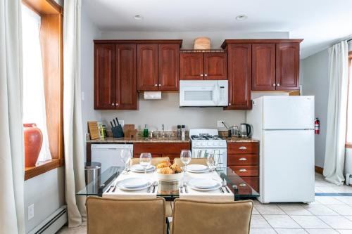 a kitchen with a table with chairs and a white refrigerator at Spacious Stay near Yale in Downtown New Haven in New Haven