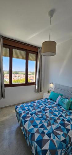 1 dormitorio con 1 cama grande de color azul en Apto Lux Sevilla en Sevilla