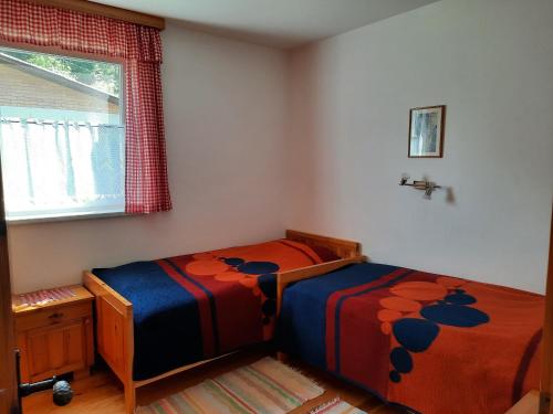 a bedroom with two twin beds and a window at Bungalows Raschun Grabelsdorf Etruskerweg 10 A-9122 St.Kanzian in Grabelsdorf