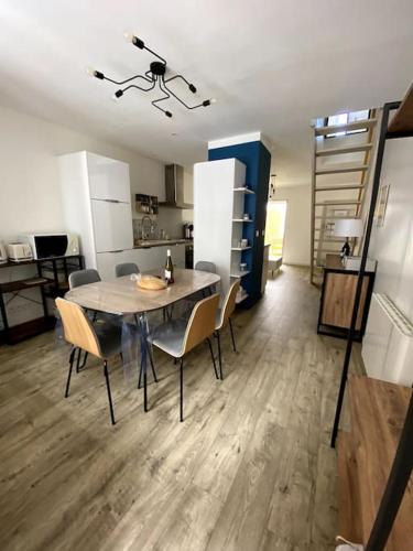 une salle à manger avec une table et des chaises dans une cuisine dans l'établissement Maison Sablaise 50m Grande Plage, à Les Sables-dʼOlonne
