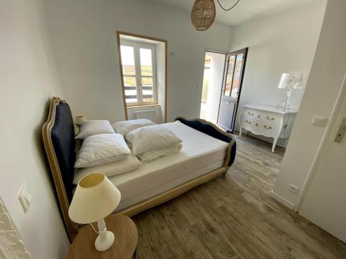une chambre avec un lit et une table avec une lampe dans l'établissement Maison Sablaise 50m Grande Plage, à Les Sables-dʼOlonne