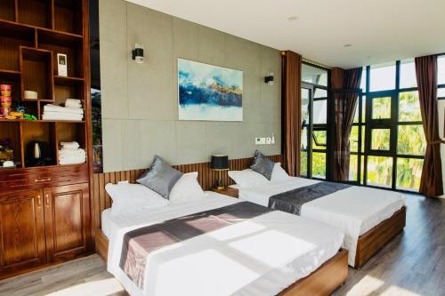 1 dormitorio con 2 camas y ventana grande en Đồng Chanh Villa Venuestay, en Hòa Bình
