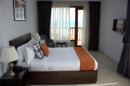 a bedroom with a bed and a view of the ocean at Destination Beach Hotel by Dreamworld in Karachi