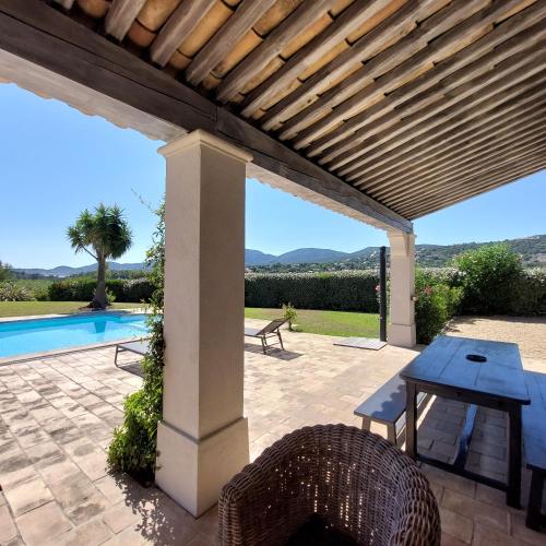 une terrasse avec une table de pique-nique et une pergola en bois. dans l'établissement La Tabarine, à La Croix-Valmer