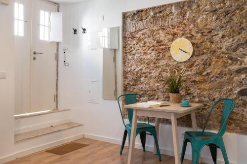 tavolo e sedie con orologio appeso a un muro di Classic Lisbon Homes: Bright & Central in Belém a Lisbona