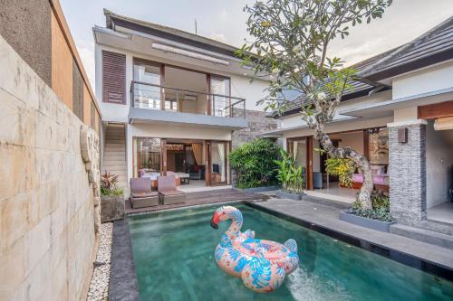 a pool in the backyard of a house with a rubber duck in the water at Nyanyi Sanctuary Villa by Ini Vie Hospitality in Tanah Lot