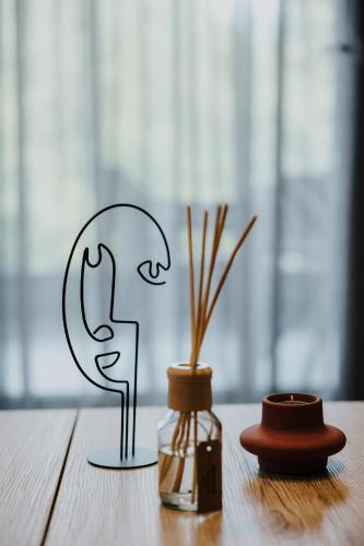 a wooden table with a candle and a vase on it at Pearl Apartel in Volos