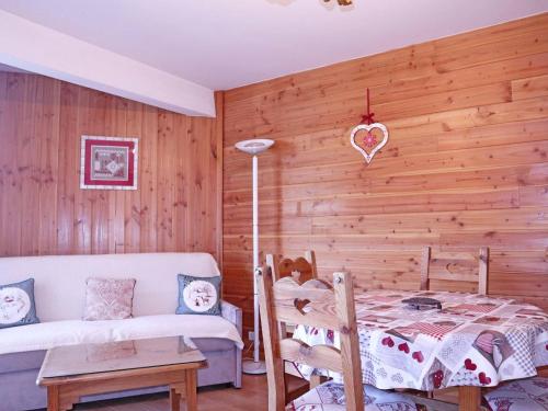 - une chambre avec un mur en bois, un lit et un canapé dans l'établissement Studio rénové pour 4, accès skis aux pieds, Les Orres - FR-1-322-51, aux Orres