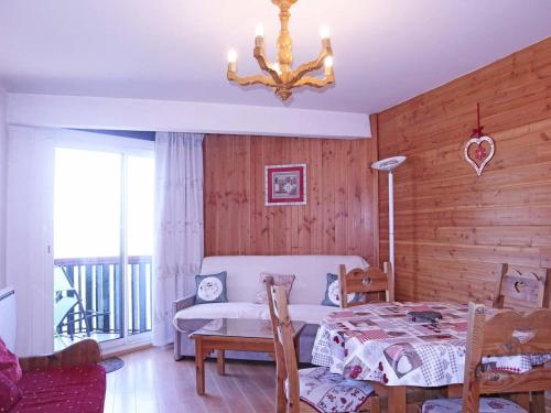 une chambre avec un lit et un lustre dans l'établissement Studio rénové pour 4, accès skis aux pieds, Les Orres - FR-1-322-51, aux Orres