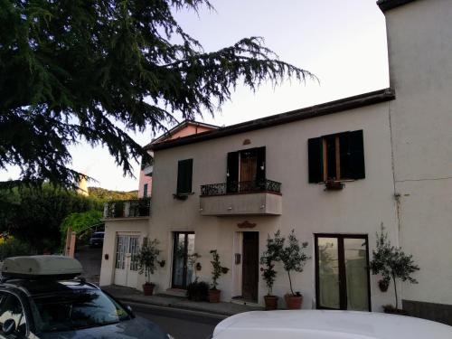 a white house with a car parked in front of it at Casa Sole di Toscana con 5 camere, grande terrazza panoramica, giardino e vasca relax idromassaggio in Monterotondo
