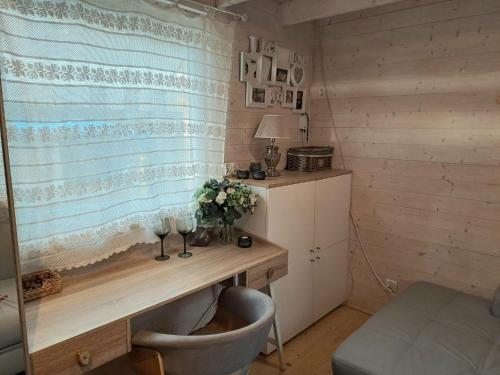 um pequeno quarto com uma secretária e uma cadeira em Bursztynowe Domki w Helu em Hel