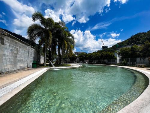 einen Pool mit Palmen in der Unterkunft ēRYA by SURIA Hot Spring Bentong in Bentong