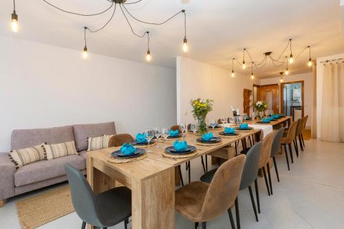 a dining room with a long wooden table and chairs at 21 Sleeps Private Pool Villa & BBQ Near Barcelona in Rocafort