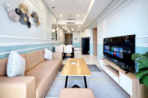 Yu Stay Apartment in Soho D1 near Bui Vien walking street في مدينة هوشي منه: غرفة معيشة مع أريكة وتلفزيون بشاشة مسطحة