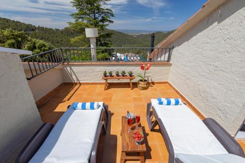 a balcony with two beds and a table at 21 Sleeps Private Pool Villa & BBQ Near Barcelona in Rocafort