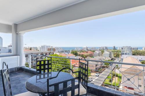 a balcony with a table and chairs and a view at Romney Park Luxury Apartments by The Stay Collection in Cape Town