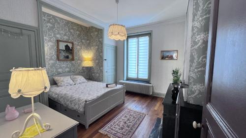 une chambre avec un lit, une table et une lampe dans l'établissement Résidence de la Marquise, à Nancy
