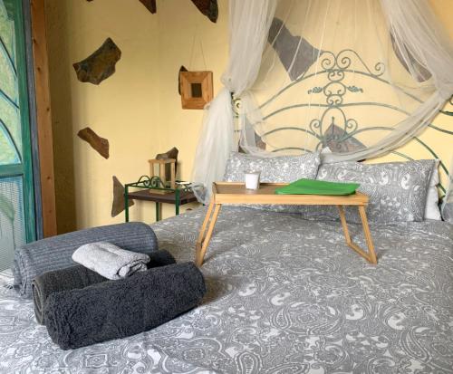 CASA RURAL CANARIA HOMBRE DE PALO في سانتا كروث دي تينيريفه: غرفة نوم مع سرير مع طاولة عليه