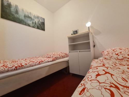 een kleine slaapkamer met 2 bedden en een kast bij Harzblick 13 in Hahnenklee-Bockswiese