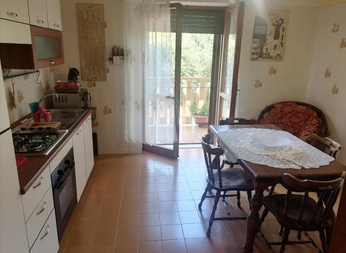 eine Küche mit einem Tisch, einem Tisch und Stühlen in der Unterkunft B&b Villaggio Sole in Sulmona