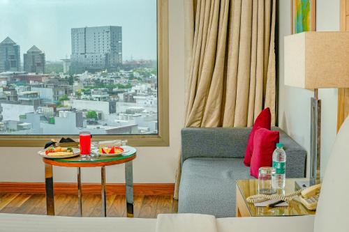 a living room with a table and a view of a city at Courtyard by Marriott Gurugram Downtown in Gurgaon