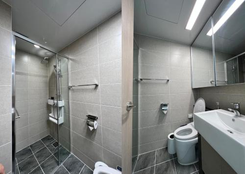 a bathroom with a shower and a toilet and a sink at UH FLAT THE SONGDO in Incheon