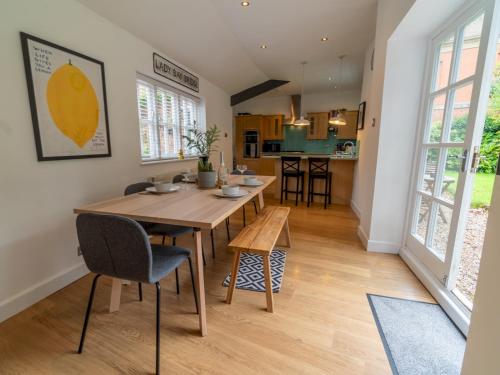 諾丁漢的住宿－Pass the Keys Beautiful 5 Guest Cottage near City Centre，厨房以及带木桌和椅子的用餐室。