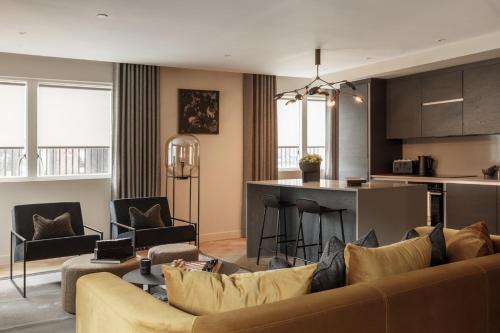 Una sala de estar con un sofá y una cocina. en 9 Kings, Hudson Quarters- FREE PARKING, en York