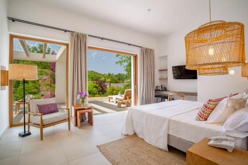 ein Schlafzimmer mit einem großen Bett und ein Wohnzimmer in der Unterkunft Can Lluc Hotel Rural in Sant Rafael de Sa Creu