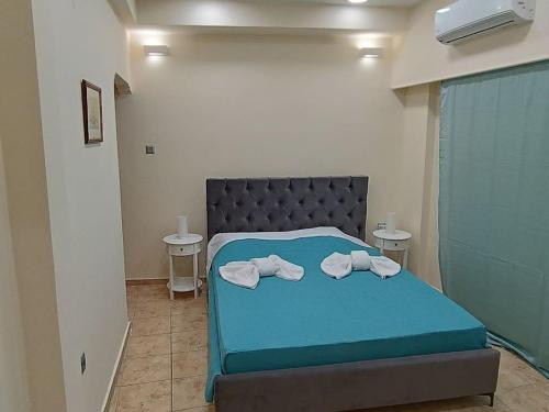 - une chambre avec un lit bleu et des serviettes dans l'établissement Athens Sky Suites 1, au Pirée