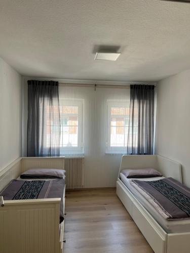 twee bedden in een kamer met twee ramen bij Lana in Freudenstadt