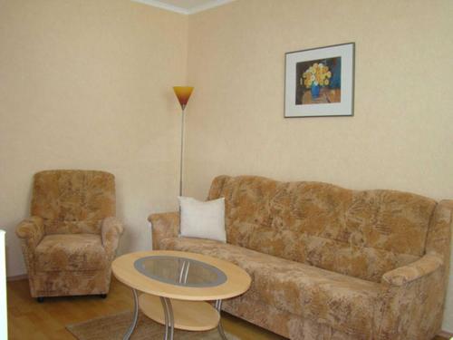 ein Wohnzimmer mit einer Couch und einem Tisch und einem Stuhl in der Unterkunft Ferienwohnungen Mülling in Heringsdorf