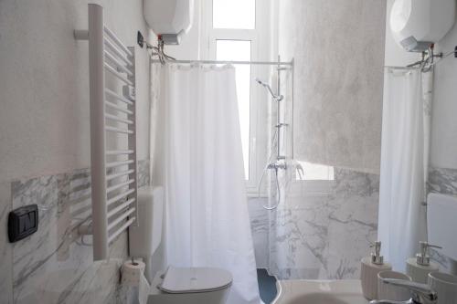 y baño con cortina de ducha y aseo. en [Twins apartament Giallo]clima en Génova