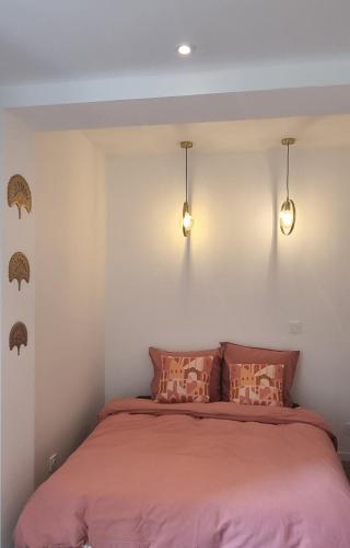 - une chambre avec un lit et deux lumières sur le mur dans l'établissement THE GREEN NATURE NEXT TO DISNEY AND PARIS, à Thorigny-sur-Marne