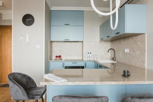 a kitchen with blue cabinets and two chairs at Apartamenty Blue in Biała Podlaska