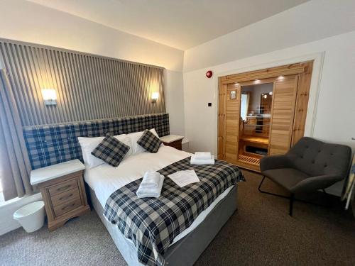 une chambre d'hôtel avec un lit et une chaise dans l'établissement The Grey Gull Hotel, à Ardrishaig