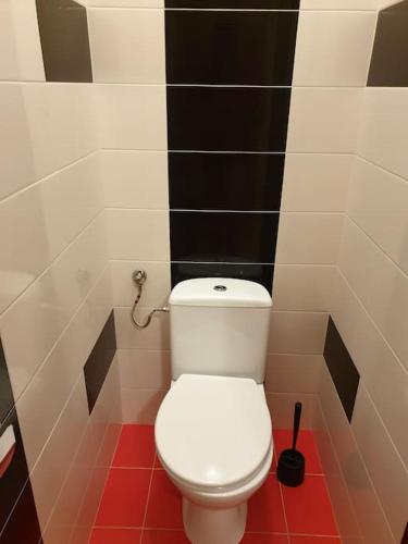 a white toilet in a bathroom with black and white tiles at Fantastic - NS54 Room I in Warsaw