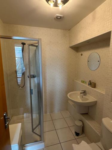 格拉斯哥的住宿－Comfy Two Bedroom Apartment Right In The City Centre，带淋浴和盥洗盆的浴室