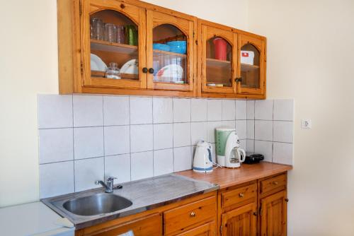 a kitchen with wooden cabinets and a sink at Giannis apartment in Kalymnos