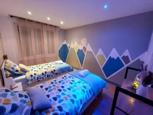 1 dormitorio con 2 camas y una pared con montañas en Le Turenne, centre-ville Belfort, en Belfort