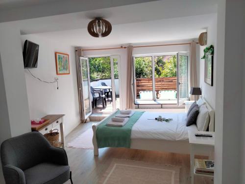 a bedroom with a bed and a chair and a window at Casa Scheiana in Braşov