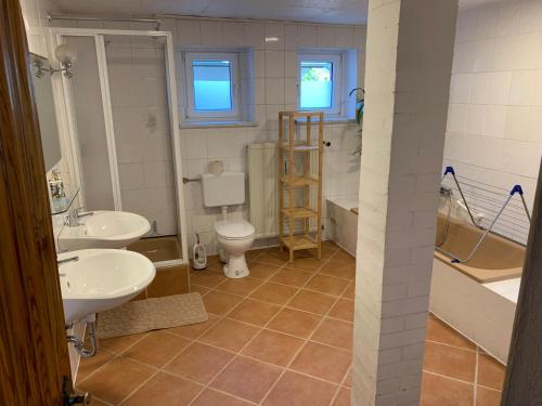 a bathroom with two sinks and a toilet and a tub at Min Hüsing in Ribnitz-Damgarten