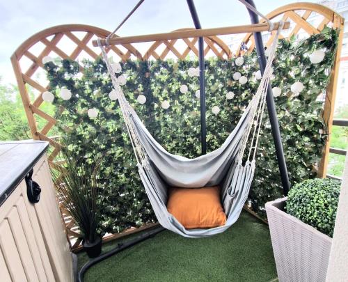 a hammock on a balcony in front of a bush at Modern and confortable apartment close to Paris in Bois-Colombes