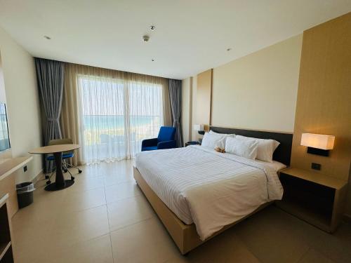 pokój hotelowy z łóżkiem i dużym oknem w obiekcie The Arena Cam Ranh Beach Front w mieście Cam Ranh