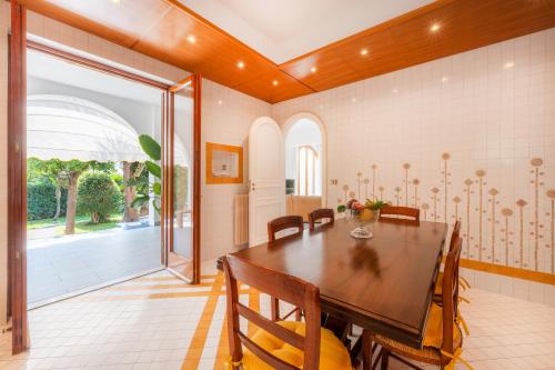 comedor con mesa de madera y sillas en YourHome - Casa Vittoria, en Meta