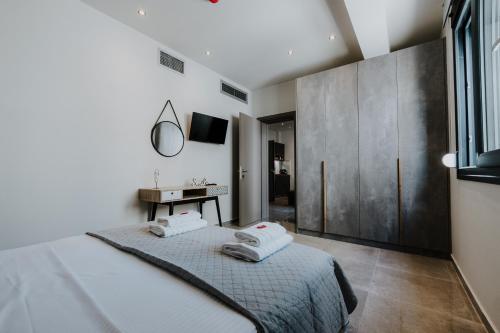 a bedroom with a bed with two towels on it at Pearl Apartel in Volos